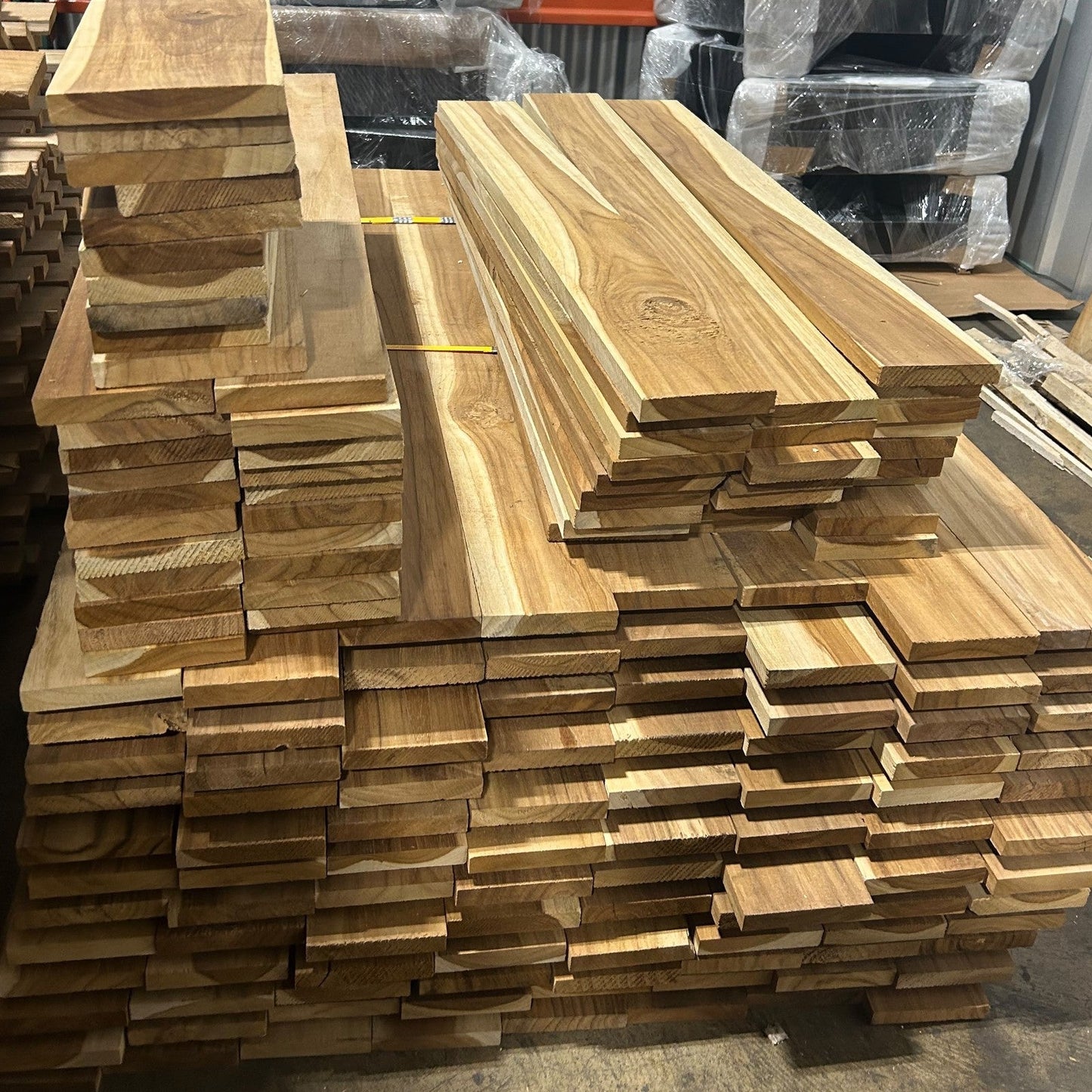 Ecuadorian plantation teak, 5–6 ft mid-length boards stacked flat at the Lincolnwood Illinois warehouse — Platinum Luxury Teak