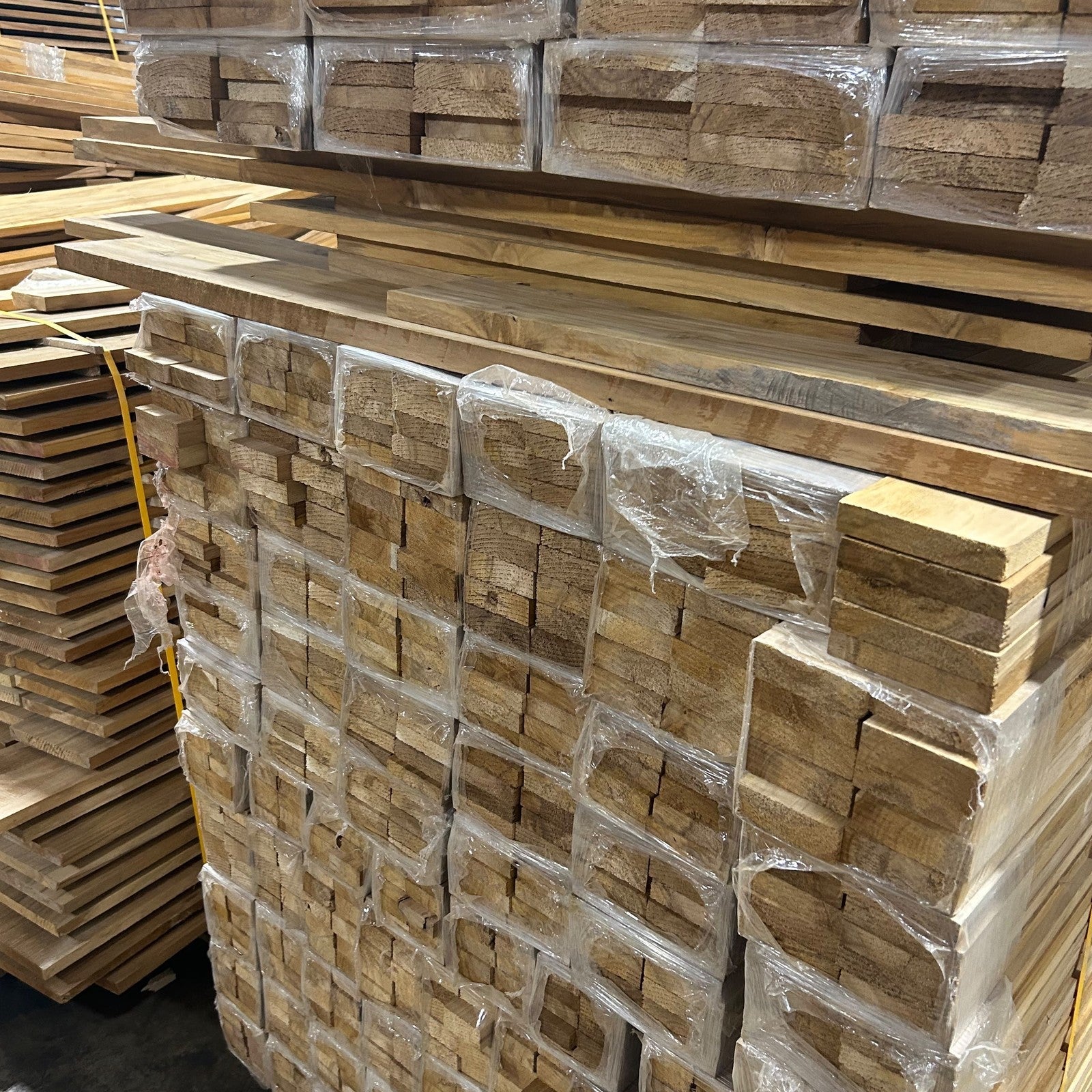 Bundled Ecuadorian plantation teak narrow stock strapped in the Lincolnwood Illinois warehouse — Platinum Luxury Teak