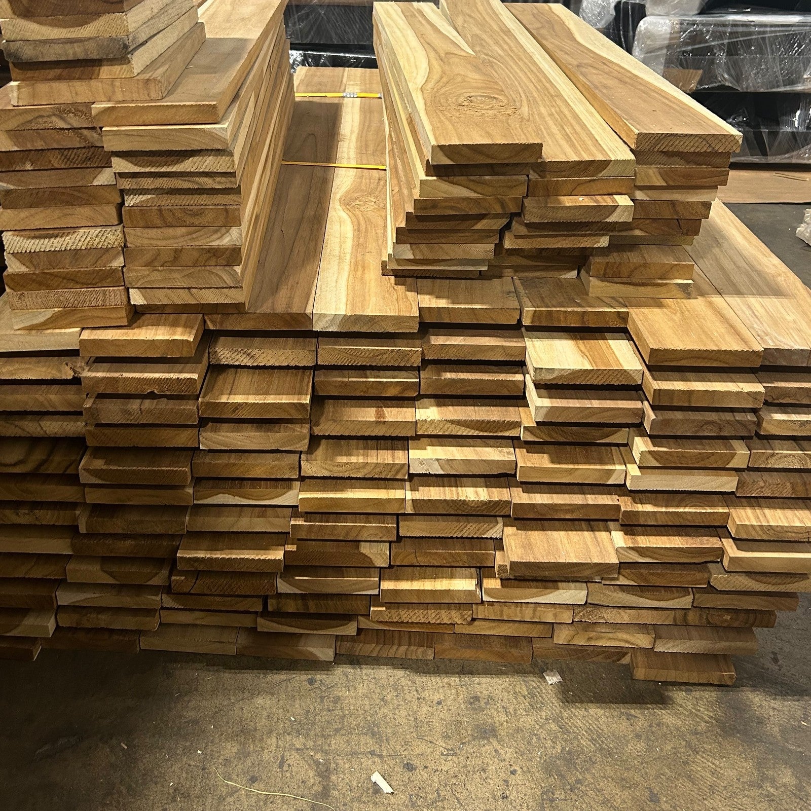 Ecuadorian plantation teak short stock, 1–4 ft boards stacked flat at the Lincolnwood Illinois warehouse — Platinum Luxury Teak
