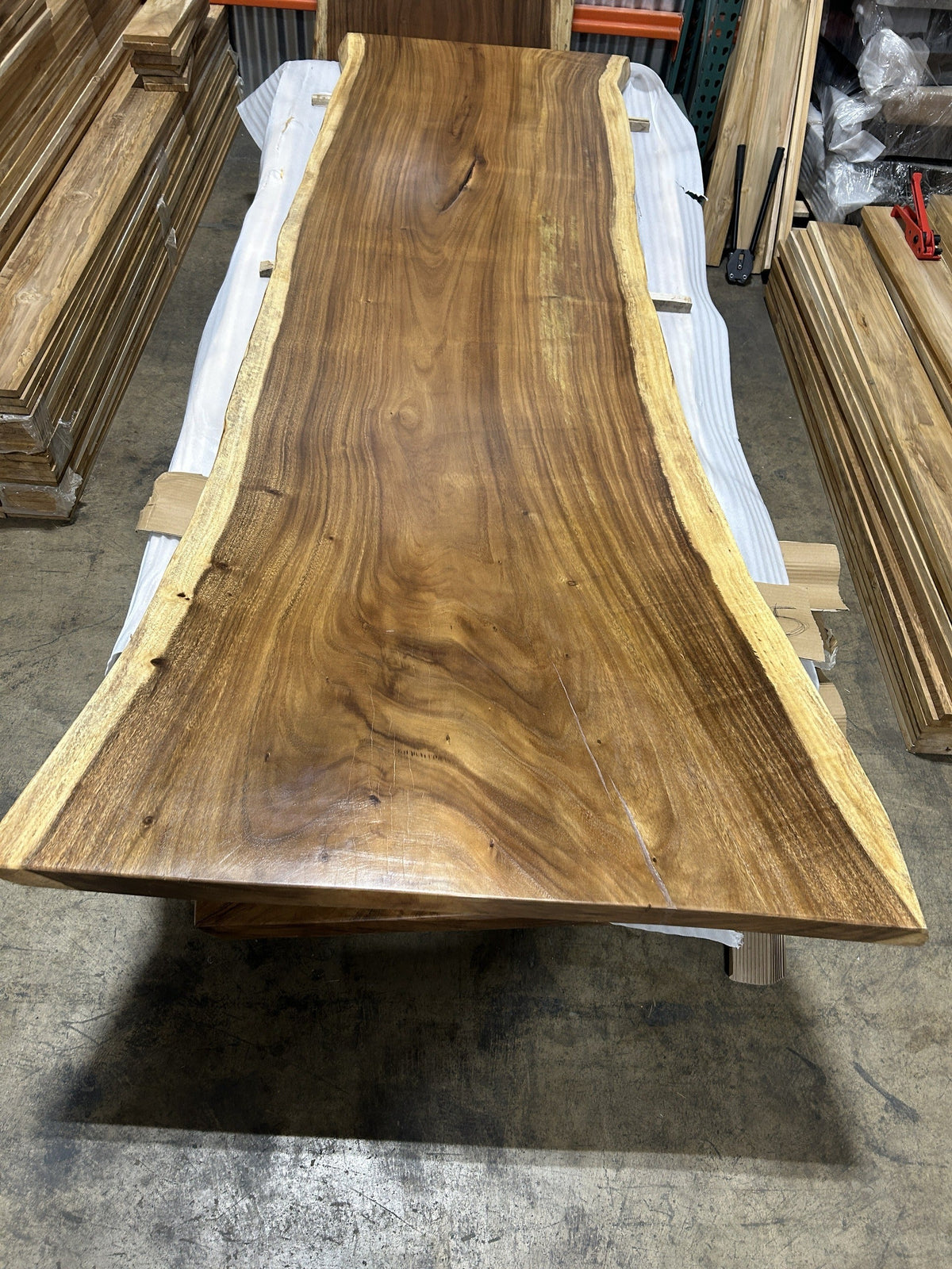 Slab No. 13, first face — the actual 9 ft single-slab Saman monkeypod top, gloss lacquer finish, photographed in our Lincolnwood IL warehouse