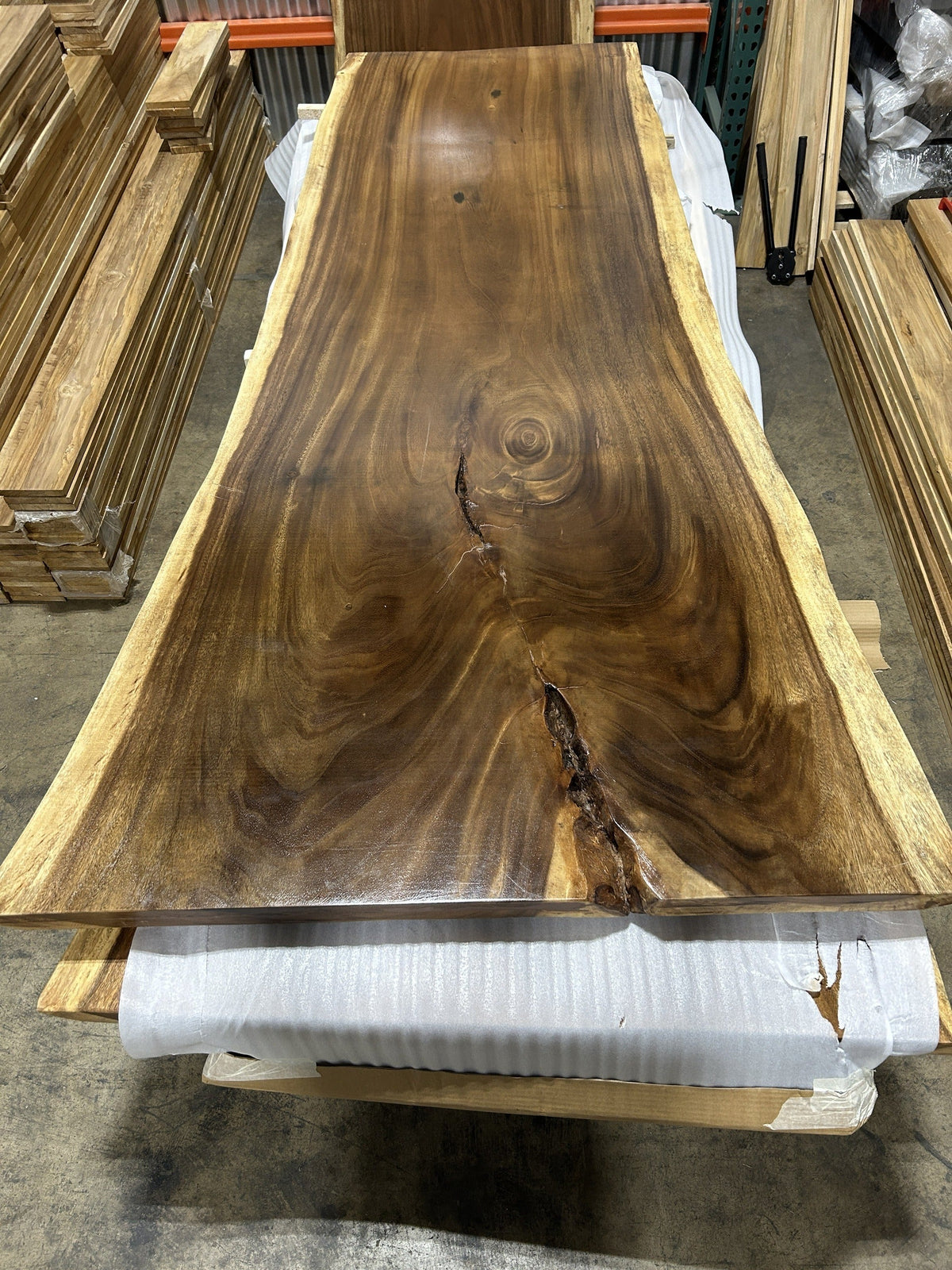 Slab No. 14, first face — the actual 8 ft single-slab Saman monkeypod top, 50 in at its widest, gloss lacquer finish, photographed in our Lincolnwood IL warehouse