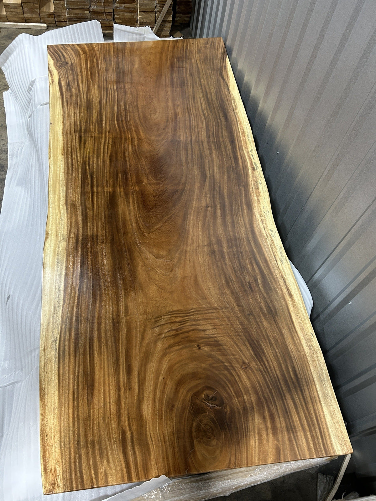 Slab No. 15, first face — the actual 8 ft single-slab Saman monkeypod top, gloss lacquer finish, photographed in our Lincolnwood IL warehouse