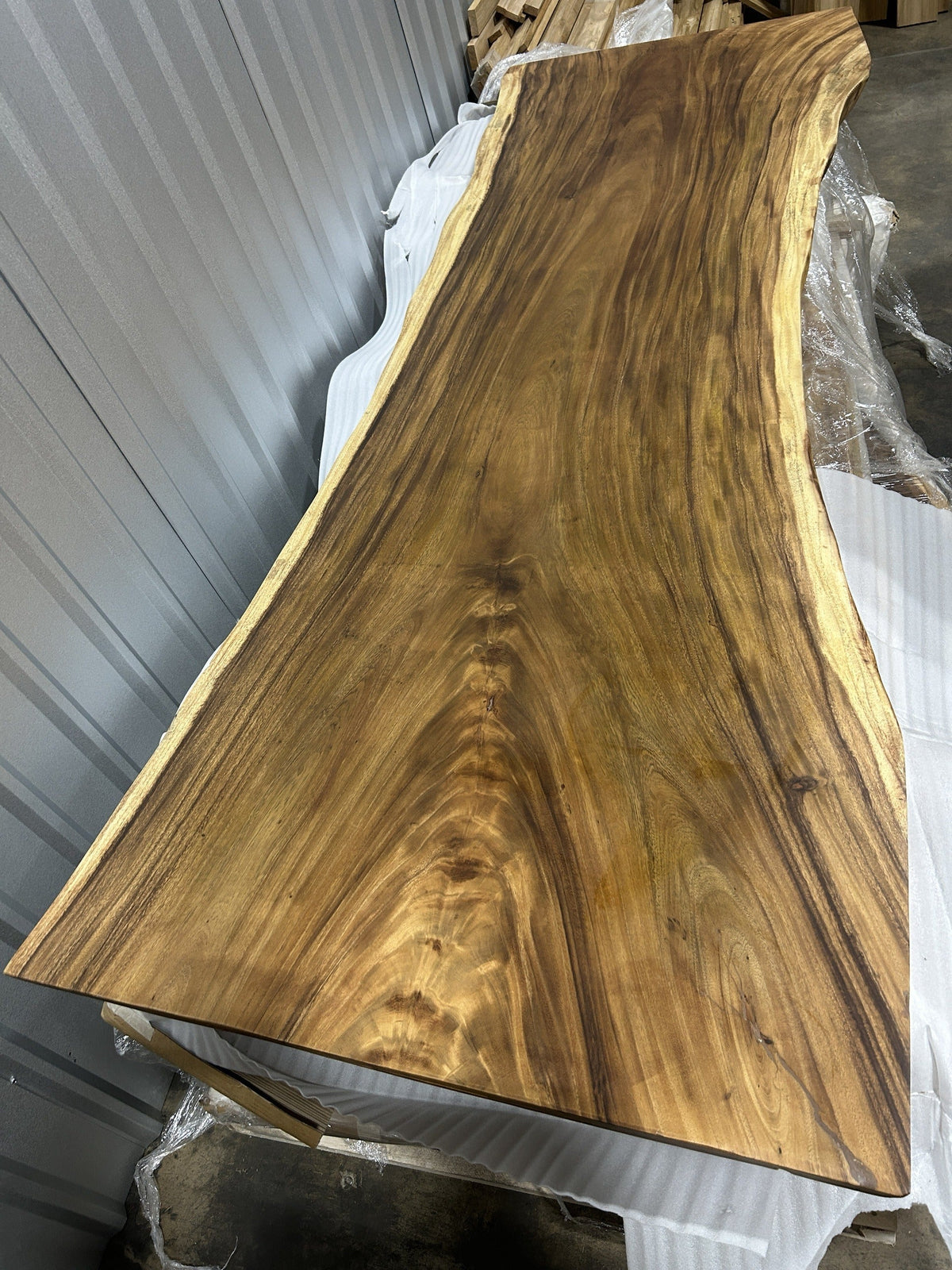 Slab No. 16 at an angle showing the 2.5 in slab thickness and full 9 ft length — actual piece, Platinum Luxury Teak, Lincolnwood IL