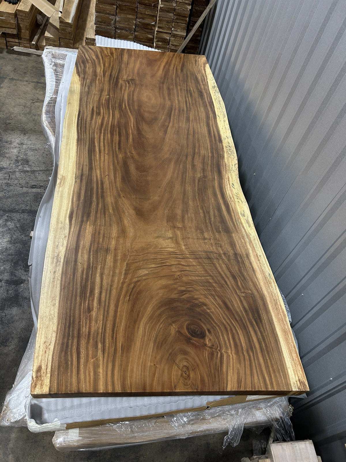 Slab No. 17, first face — the actual 8 ft 4 in single-slab Saman monkeypod top, matte lacquer finish, photographed in our Lincolnwood IL warehouse