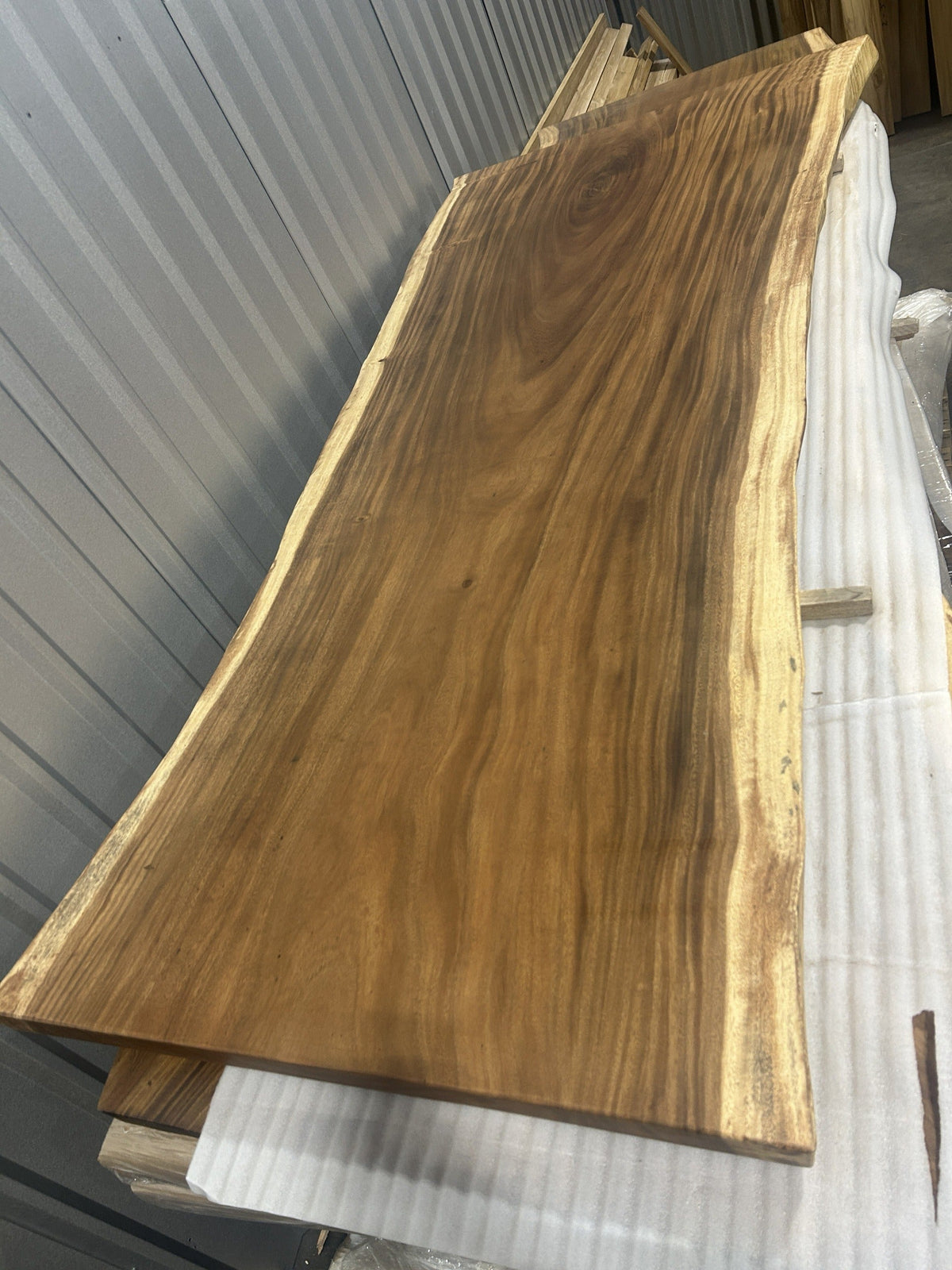 Slab No. 19, first face — the actual 8 ft 4 in single-slab Saman monkeypod top, matte lacquer finish, photographed in our Lincolnwood IL warehouse
