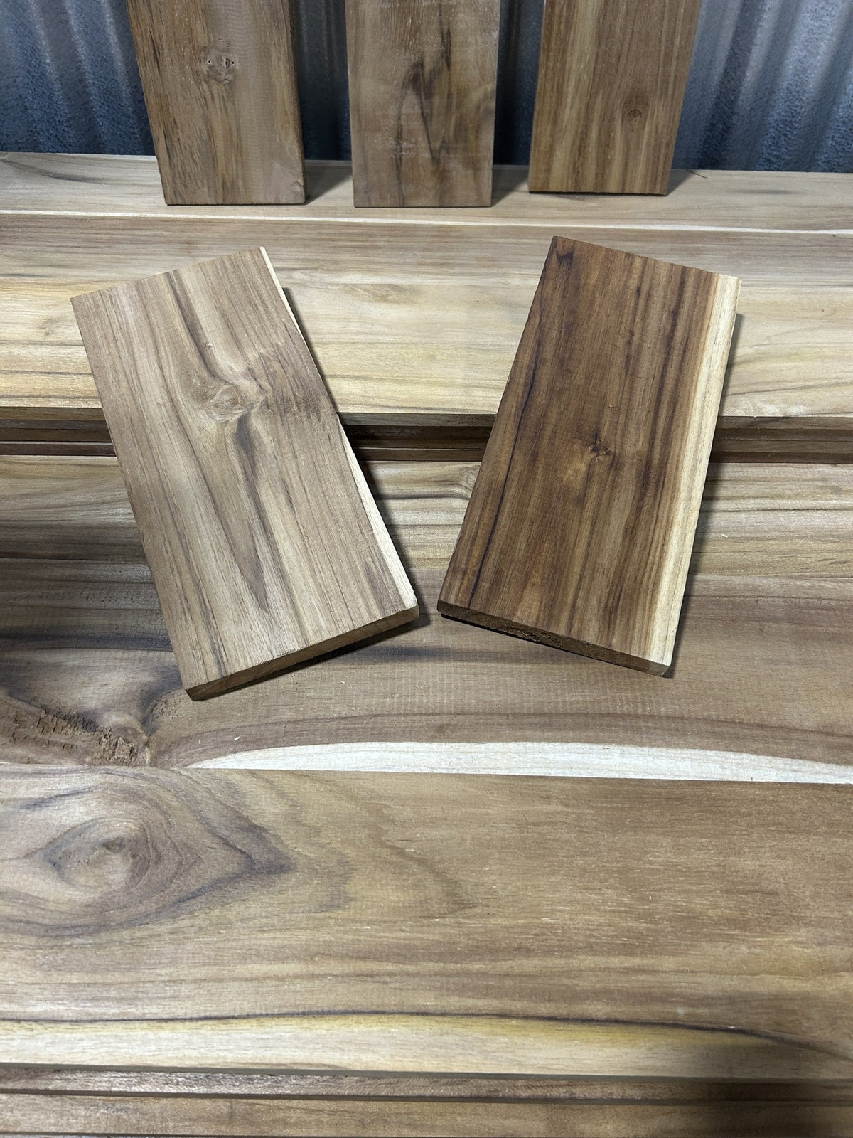 Two small Ecuadorian teak blanks for knife scales and box work, laid on a teak board — Short Teak Stock, Platinum Luxury Teak, Lincolnwood IL